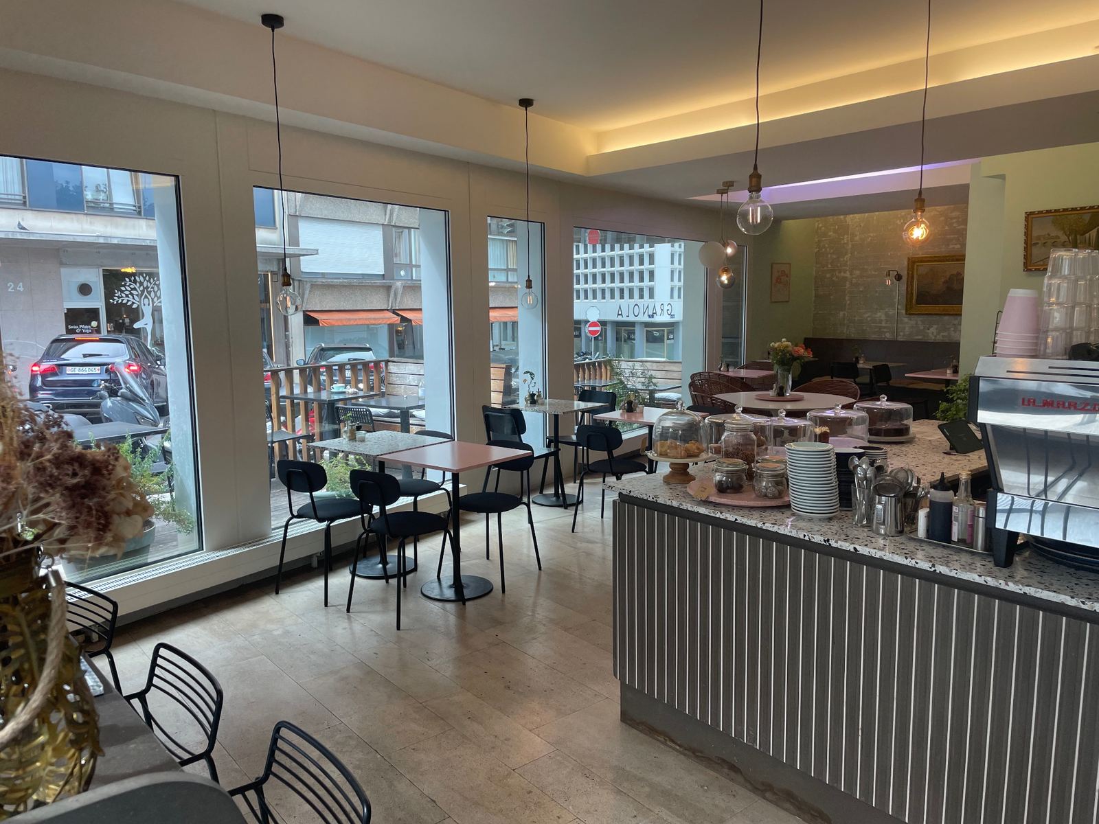 Intérieur du café Granola Geneva - salle chaleureuse avec comptoir et suspensions
